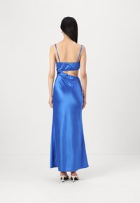 Vestido longo de cetim azul, sem mangas, com silhueta ajustada, detalhe de costas abertas e saia fluida, textura suave e alças minimalistas.
