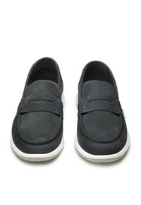 Scarpe slip-on in pelle grigia scura con suola bianca, caratterizzate da una texture liscia e un design minimalista, rifinite con dettagli cuciti.