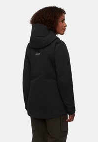 Schwarze Outdoor-Jacke mit Kapuze, ausgestattet mit einer glatten Textur und einem Logo auf dem Rücken. Das Design umfasst verstellbare Manschetten und eine taillierte Passform.