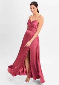 Langes Satin-Kleid in tiefem Rosé, mit herzförmigem Ausschnitt, d�ünnen Trägern, einem Oberschenkel-hohen Schlitz und einem fließenden Rock. Subtile Glanz und glatte Textur.