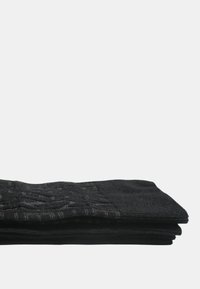 Sorte sokker stablet ensartet, med et diskret mønster og tekstur, lavet af et glat stof med en blød finish.