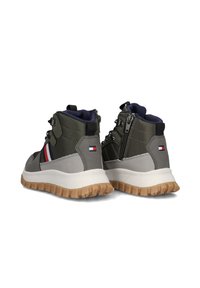 Mid-top sneakers in donkergroen en grijs met een gestructureerde afwerking, voorzien van een zijrits, een witte zool en een rubberen loopzool met grippatronen.