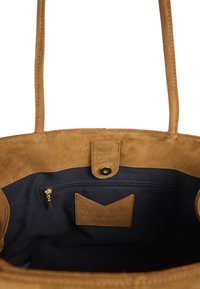 Sac cabas en daim marron avec une texture douce, doté d'une doublure en tissu foncé, d'une poche intérieure zippée et d'un détail de fermeture à pression.