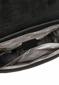 Interior de bolso de ante negro con forro de satén gris claro que presenta un patrón de diamantes, dos bolsillos con cremallera y una etiqueta de marca.