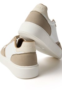 Beige und weiße Sneakers mit einem strukturierten Obermaterial, glatten Leder-Details und einer dicken weißen Gummisohle. "PIOMBO" ist auf der Ferse geprägt.