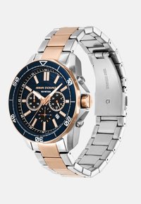 Roostevabast terasest kell, millel on roosakuldne aktsent, must kellaketas, kronograafi funktsioonid, numbrilised markerid ning hõbe- ja roosakuldne linnukett.