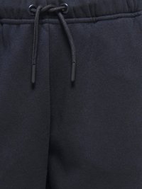 Navy blue sweatpants featuring a textured fabric, elastic waistband, and a drawstring tie. Includes black plastic tips on the drawstring.