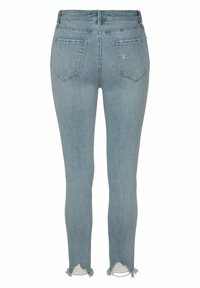 Jeans skinny in denim blu chiaro con vita alta, caratterizzati da orli strappati e due tasche posteriori. Il tessuto presenta una leggera scoloritura e sfumature.