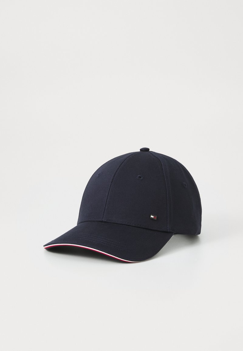 Casquette de baseball bleu marine avec un petit logo rectangulaire sur le côté et une fine bordure rouge et blanche sur le bord de la visière incurvée.