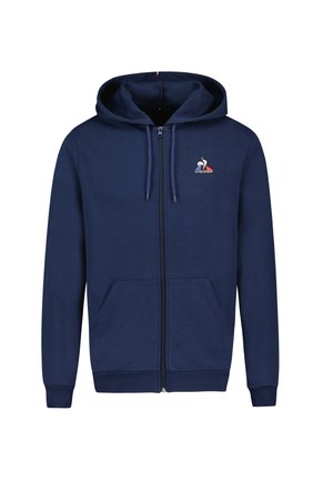 Námořnická modrá mikina s kapucí na zip, vyrobená z měkkého materiálu; má dvě přední kapsy, kapuci se stahovací šňůrkou a logo na levém prsu.