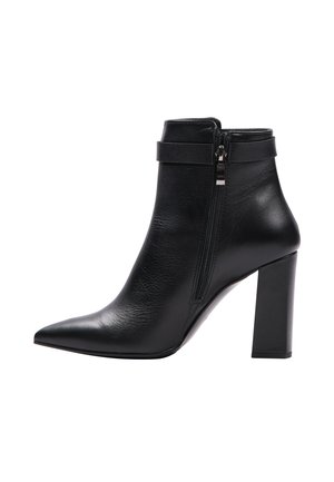 Černá kožená kotníková bota s špičatou špičkou, bočním zipem a silným blokovým podpatkem. Obsahuje pásek kolem kotníku pro dodatečný detail.