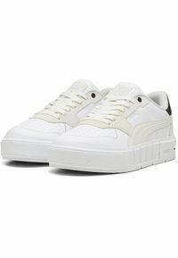 Baskets blanches avec une semelle texturée, une tige en cuir lisse, un bout perforé et un accent noir contrastant au niveau du talon. Présente un design à lacets.