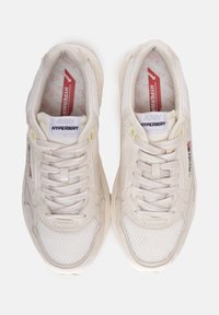 Scarpe da ginnastica beige chiare con pannelli in rete, design strutturato, punta rinforzata e linguetta imbottita. Presentano lacci e accenti di marca.
