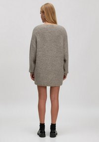 Strickkleid in Hellgrau mit lockerer Passform, rundem Halsausschnitt und langen Ärmeln, ausgestattet mit einem strukturierten Muster und einer Länge bis zur Mitte des Oberschenkels.