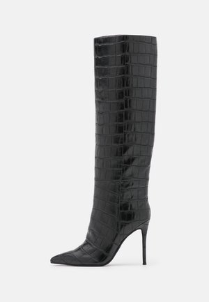 Czarna, wysokokolanowa, na obcasie, z teksturą skóry krokodyla i spiczastym noskiem, przedstawiona z boku na białym tle.