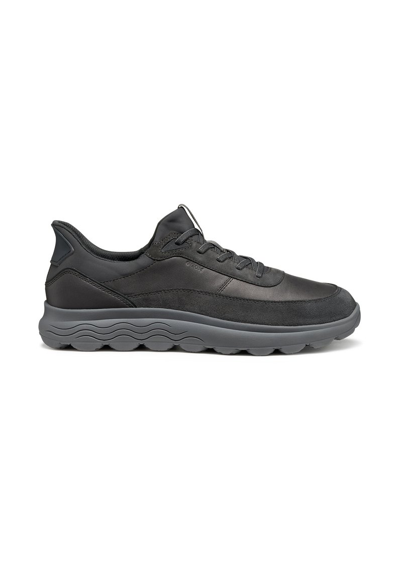 Sneaker nera bassa con chiusura con lacci, tomaia in suede e pelle, e suola spessa con motivo ondulato per un look informale.