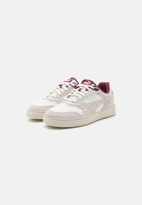 Zapatillas blancas y gris claro con un upper de cuero liso y ante texturizado. Acabados burdeos en la lengüeta y los cordones. Suela de goma.