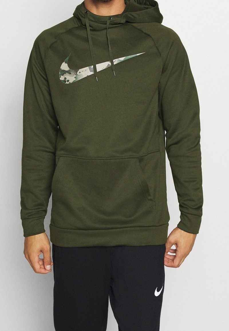 Hoodie vert olive avec un logo Nike camouflage, doté d'une poche avant, d'une capuche avec cordon de serrage et de poignets côtelés. Texture de tissu douce et lisse.