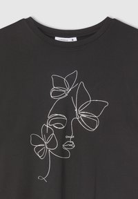 T-shirt nera con collo rotondo, caratterizzata da un'arte a linee astratte bianche che raffigura un volto e farfalle. Tessuto morbido con maniche corte. Tag della taglia S visibile.