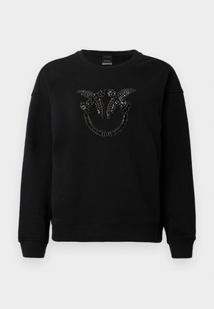 Svart crewneck sweatshirt med to svarte juvelbesatte fugler som vender mot hverandre over en juvelbesatt halvsirkel på brystet.