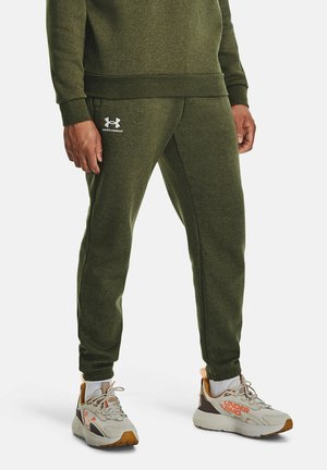 Olivgrön joggers i mjukt tyg, med resårmidja, en tapered bendesign och en vit Under Armour-logga på sidan.