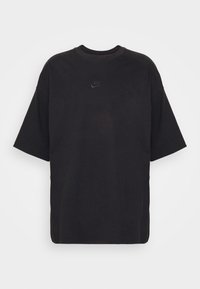 Mustan ylimitoitettu T-paita, joka on valmistettu puuvillasta. Paita sisältää pyöreän kaula-aukon, lyhyet hihat ja pienen kohokuvioidun Nike-logon rinnassa.