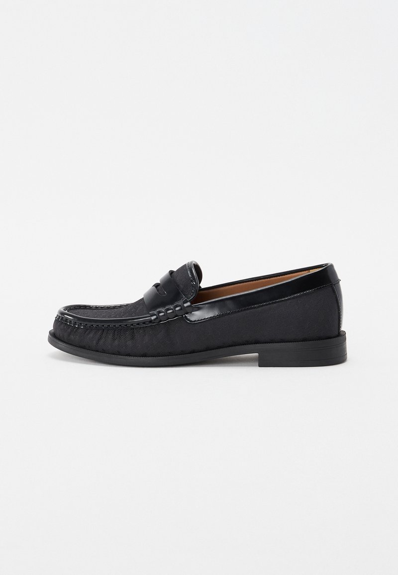 Černé slip-on loafery vyrobené z texturované tkaniny s lesklým koženým akcentem a jemnými švy, s nízkým gumovým podpatkem.