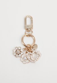 Portachiavi dorato con moschettone, caratterizzato da tre ciondoli: uno decorato con cristalli trasparenti, un fiore con una perla e un design iniziale decorativo.