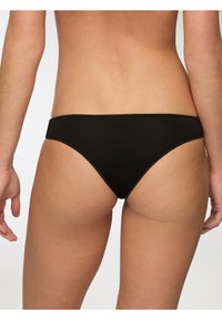 Bikini bottom in cotone nero con una texture liscia, design a vita bassa e copertura minima. Presenta una cintura elastica pulita e dettagli di cucitura.