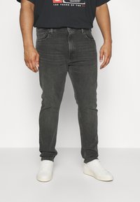 Grijze denim jeans met een slim fit, voorzien van een klassieke vijf-pocket design, aangevuld met een eenvoudig zwart T-shirt en witte sneakers.