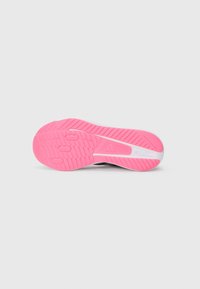 Semelle de chaussure avec un fond en caoutchouc rose, présentant des motifs de crampons texturés et un intercuir en plastique blanc pour la stabilité et l'adhérence.