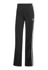 Pantalones de chándal negros hechos de tela suave, con una cintura elástica ajustable, dos bolsillos laterales y rayas blancas en los laterales. Logo de Adidas visible.