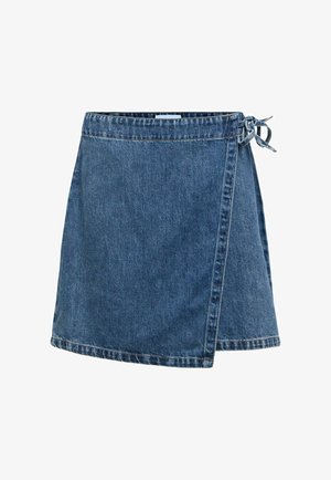 Jupe portefeuille en denim bleu avec fermeture à nouer sur le côté et coutures visibles sur fond blanc.