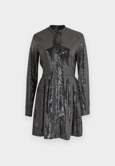 Abito nero con paillettes, maniche lunghe e collo alto, caratterizzato da un corpetto aderente e gonna a campana. Tessuto riflettente in tutto il vestito.