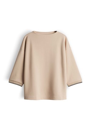 Beige oversized sweatshirt featuring a round neck and three-quarter sleeves. The cuffs have black accent stripes. Soft, smooth texture.