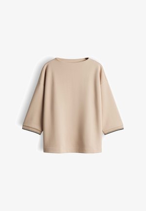 Beige oversized sweatshirt featuring a round neck and three-quarter sleeves. The cuffs have black accent stripes. Soft, smooth texture.