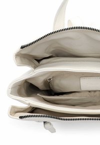 Valge nahast käekott tekstuurse viimistlusega. Omab lukuga sulgemist, beeži kangast voodrit ja mitmeid sisemisi taskuid.