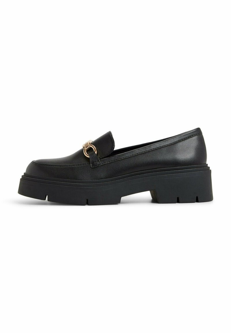 Svarta läderloafers med en kraftig gummisula, prydda med en dekorativ guldfärgad accent framtill. Slät yta och strömlinjeformat design.