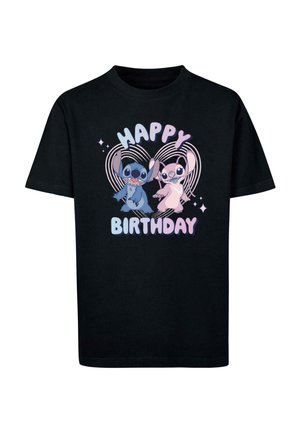 T-shirt in cotone nero con una grafica di due personaggi dei cartoni animati e la scritta "BUON COMPLEANNO" in colori pastello e cuori decorativi.