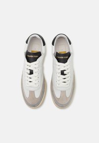 Pantofi sport din piele albă cu accente din sufle gri, tab cu toc negru, șireți albi lăsați și o talpă din cauciuc de culoare crem. Branding auriu pe limba pantofului.