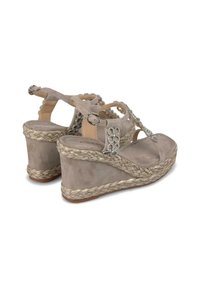 Sandales compensées beiges en daim avec des détails en jute tressé. Présente des embellissements décoratifs sur les brides et un design à dos ouvert.