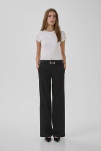 Jeans negros de pierna ancha con un acabado texturizado, combinados con una camiseta ajustada de manga corta blanca con un sutil detalle bordado.