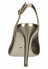 Scarpa con tacco alto in metallo dorato, dalla punta affilata e sottile stiletto. Presenta una cinghia alla caviglia con fibbia e una superficie liscia.