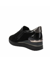 Scarpa nera con un mix di suede opaco e pelle verniciata lucida. Tacco a zeppa elevato con dettagli metallici e pannelli laterali elastici.