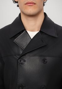 Zwarte leren dubbele breasted jas met grote revers, voorzien van twee knopen, een gladde textuur en een op maat gemaakt ontwerp. Geen zichtbare patronen of accenten.