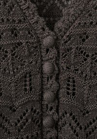 Dark gray crocheted fabric with leaf and diamond patterns and a row of round, fabric-covered buttons down the center.