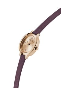 Montre ovale dorée avec un cadran crème, trois accents en diamant et un bracelet en cuir bourgogne texturé. Design minimaliste avec un détail de couronne.