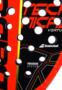 Rød padelracket med et sort hexagonalt mønster, har store hvide huller, teksten "Vibrabsorb System" og gule og røde accentlinjer.