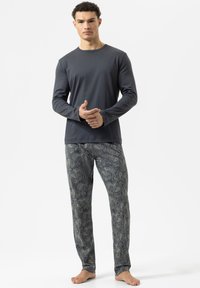 Langdurige mouwen donkergrijs shirt gecombineerd met een gestreepte pyjamabroek met een ingewikkeld blauw en beige paisley ontwerp.