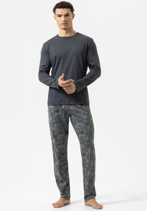 Langärmliges dunkelgraues Hemd kombiniert mit gemusterten Pyjamahosen, die ein komplexes blau-beige Paisley-Muster aufweisen.
